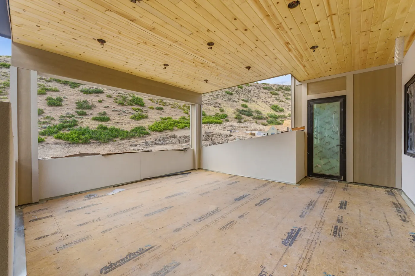 Covered terrace with wood-plank ceiling opening to the mountains