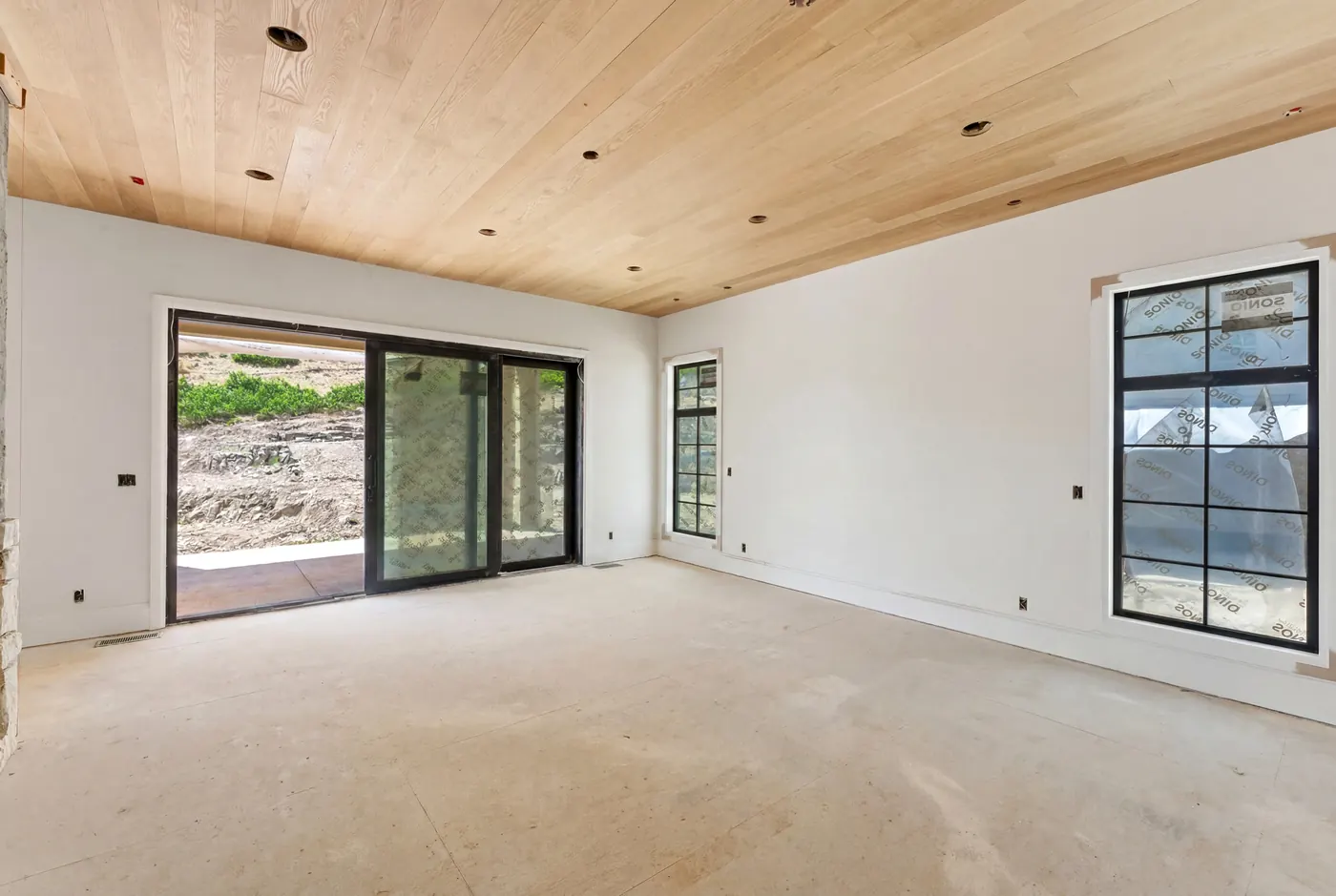 Primary suite with wood-beamed ceiling and glass doors to the courtyard